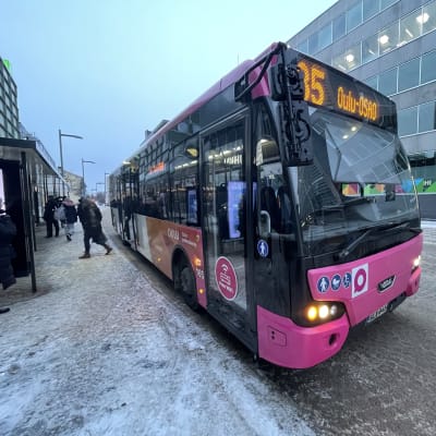 Pinkki bussi bussipysäkillä.