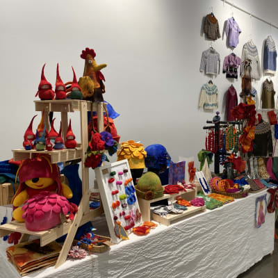 Värikkäitä tekstiilituotteita, esimerkiksi tonttuja, hattuja, villasukkia ja villapaitoja Tornion neulefestareilla.
