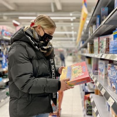 Suvi Turpeinen katselee käsissään olevaa lautapelilaatikkoa.