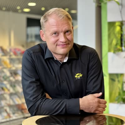 Liiga-SaiPa Oy:n toimitusjohtaja Jussi Markkanen nojaa pöytään Lappeenrannan kaupungintalon aulassa.