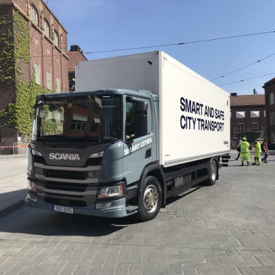 Vit lastbil med texten "smart and safe citytransport" på sidan.