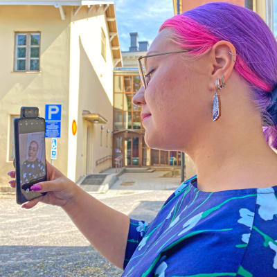 Nainen ottaa itsestään selfietä puhelimella