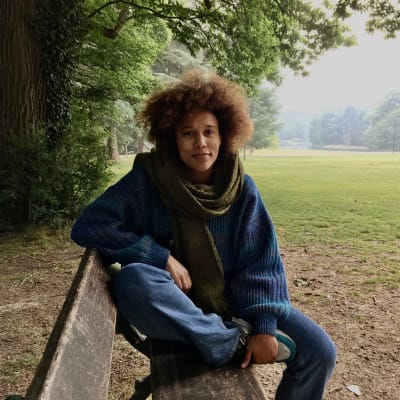 Stephanie Collingwoode Williams fotograferad i en park i Bryssel. Hon är en kvinna i 30-årsåldern, ledigt klädd med en halsduk runt halsen. 