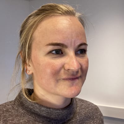 Nuori, vaaleatukkainen nainen tiukassa lähikuvassa.