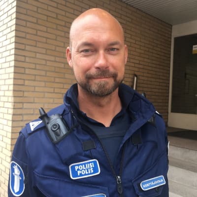 överkonstapel vesa hanski har full polisdräkt på i mörkblått och med olika polismärken på.