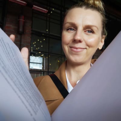Hanna Gullichsen kauppakirjojen takana.