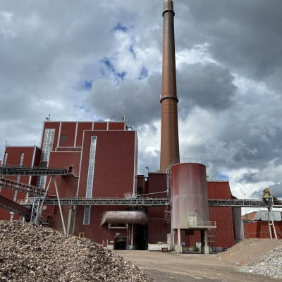 Kaipolan suljetun paperitehtaan voimalaitos, Laitoksen edessä pihalla on taivaslla kierrätysmuovin kasoja ja kivikasa, johon on seulottu kierrätysmuovin seassa olleita kiviä