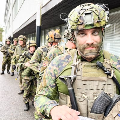 Flera militärklädda i en kö.