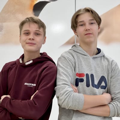 Joona Aittokumpu ja Onni Riikola katsovat hymyillen kameraan kädet puuskassa edessä.