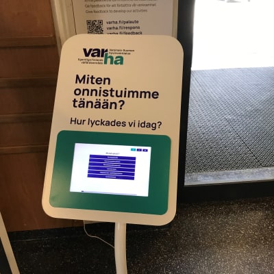Varsinais-Suomen hyvinvointialueen palauteautomaatti terveysaseman sisäänkäynnin vieressä.