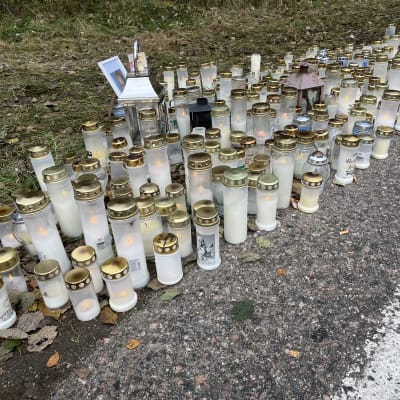 Tien reuna, runsaasti hautakynttilöitä palamassa