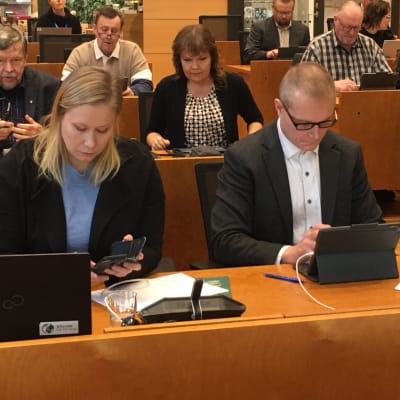 Ylöjärven kaupunginvaltuuston kokouksessa ruskean pöydän ääressä istuvat Perussuomalaisten valtuustoryhmän puheenjohtaja Hannu Ruuska, taustalla istuu Erja Pelkonen. Kuvauspäivä 9.10.2023.