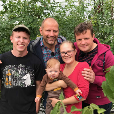 John Silander, Matias Jungar, lilla Sidonia Silander, Runa-Linn Silander och Michael Björklund står i ett växthus där det odlas tomater.