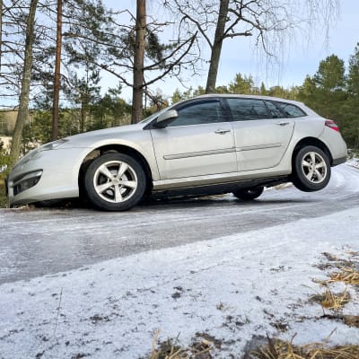 En bil med fören i diket och ett bakdäck i luften på en isig skärgårdsväg.