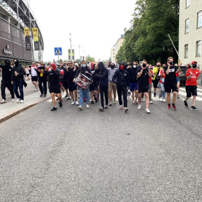Jalkapallofanit marssivat kadulla.