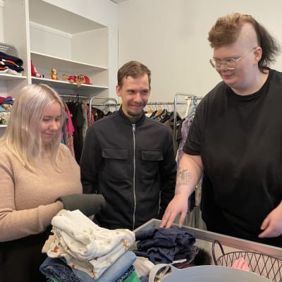 Jenna Häkälä, Eemeli Kumpulainen ja Hanna Nousiainen lajittelevat lahjoituksena saatuja vaatteita Ilmaisessa Puodissa.