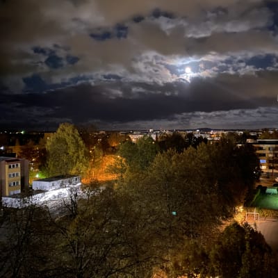 Iltaöinen kuva kuutamosta ja kaupungin valoista Hämeenlinnan Kaurialasta 10.10.2022.