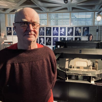 Lahden Kaupunginteatterin johtaja Ilkka Laasonen poseeraa lavasteen pienoismallin edessä.
