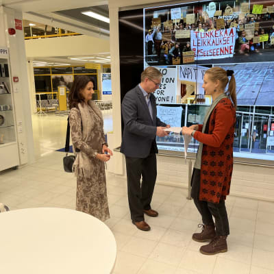  Rehtori Jari Ojala ja vararehtori Marja-Leena Laakso vastaanottavat adressin, sen luovuttaa Marjukka Niskanen.