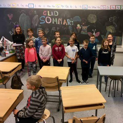 Salo svenska skola sjunger, läraren spelar piano.