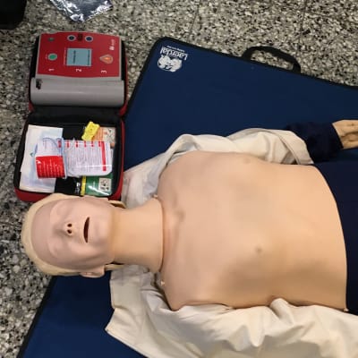 Första hjälpen-docka med defibrillator.