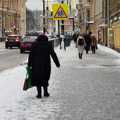 Fotgängare går på trottoar i Sankt Petersburg.
