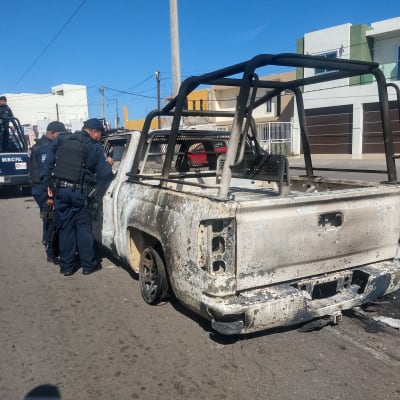 Poliisit tutkivat palanutta autoa.