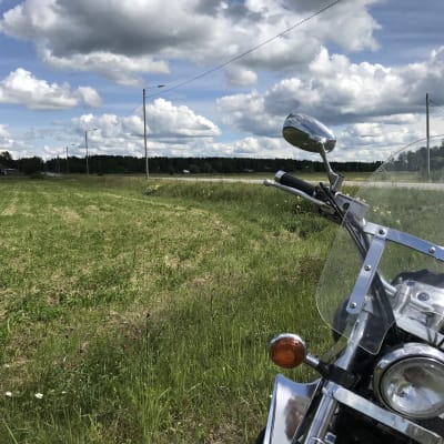en motorcykel invid en åker och bilväg