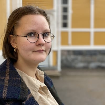 Anetta Kukkonen seisoo koulun sisäpihalla.