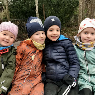Fyra dagisbarn ute med varma kläder.