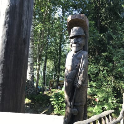 Seppo Laatusen puuveistos, joka esittää Urho Kekkosta onki ja kala kädessä.