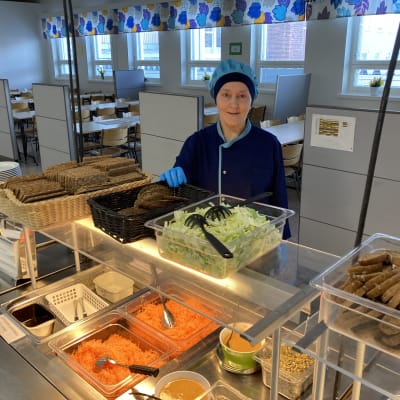 Kortepohjan koulun ruokapalveluvastaava Senja Lankinen seisoo ruokalinjaston takana.