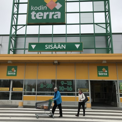Nokian Kodin Terran myymälän etupiha, kaksi ihmistä kulkemassa pääovien edustalla