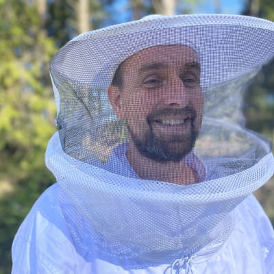Mehiläistarhaaja Mikko Holmi suojavarusteet yllään Hämeenlinnan Rengossa 24. toukokuuta 2022.