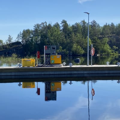 Venetankkausasema laiturilla. Taustalla vehreä saari.