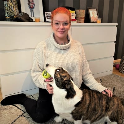 Jonna Shemeikka hymyilee kameralle koira sylissään.