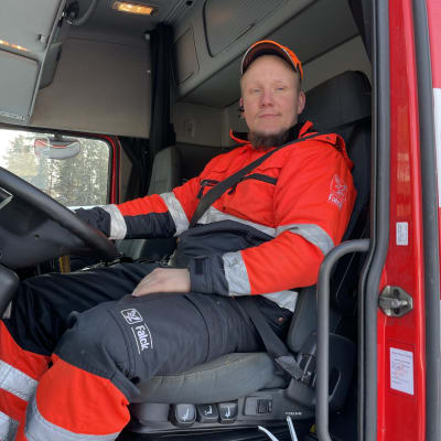 HInausautonkuljettaja Henri Kasanen istuu ison hinurin ratissa helmikuussa 2023. 