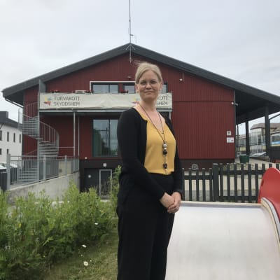 Kvinna poserar framför byggnad