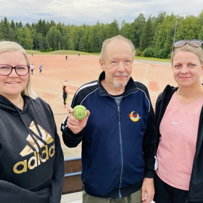 Puulaakipesäpalloilijat Eeva Korhonen Anu Hurtig ja Arto Köngäs seisovat tyytyväisenä Korkalovaaran pesäpallostadionilla.