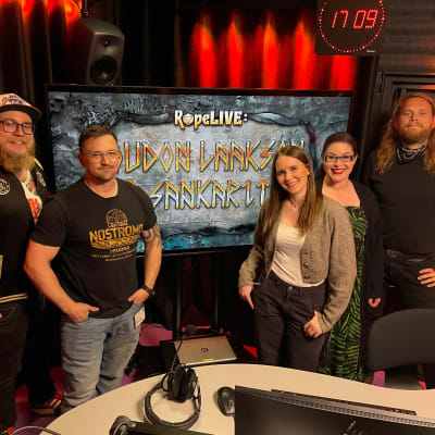 Womma Seppälä, Miska Fredman, Beata Rodas, Maria Pettersson ja Juhani Kenttämaa seisovat radiostudiossa. Taustalla RopeLIVE: Oudon laakson sankarit -tunnusgrafiikka. 