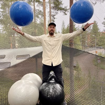 Vuokatin Netparkin yrittäjä Priidik Vesi heittää palloja ilmaan verkkohuoneessa puussa.