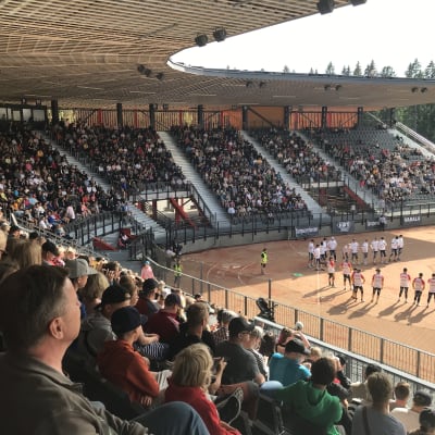 Uuden Kaupin stadionin ensimmäinen ottelu on alkamassa ja yleisö katselee pelin alun tapahtumia.