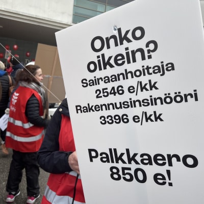 Tehyn mielenosoittajien käsissä plakaatti, jossa lukee: Onko oikein? Sairaanhoitaja 2 546 €/kk, rakennusinsinööri 3 396 €/kk. Palkkaero 850 €!