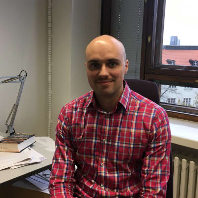 Bild på forskare Ryhor Niznikau på hans kontor på utrikespolitiska institutet. 