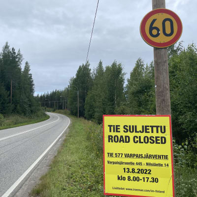 Kyltti Ironman-kilpailun vaikutuksista Nilsiän ja Varpaisjärven välisen tien liikenteeseen.