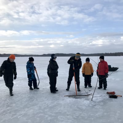 Kangasniemen Äkryn koululaisia jäällä, avantoa kairataan.