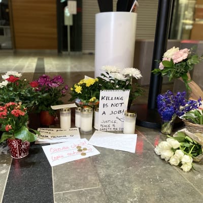 Blommor, ljus och kort vid en minnesplats