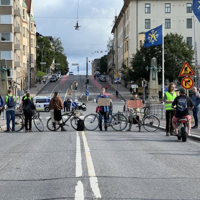 Bild av personer som blockerar körfältet på Aurabron i Åbo. 