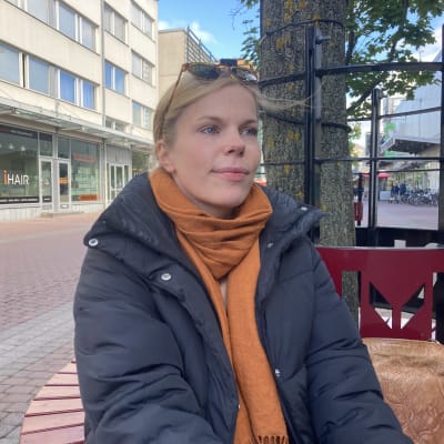 Mira Piitulainen istuu penkillä.