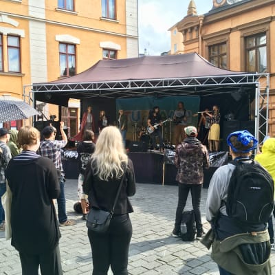 Publiken lyssnar på ett band som spelar på Mad Pride på Gamla Stortorget i Åbo.